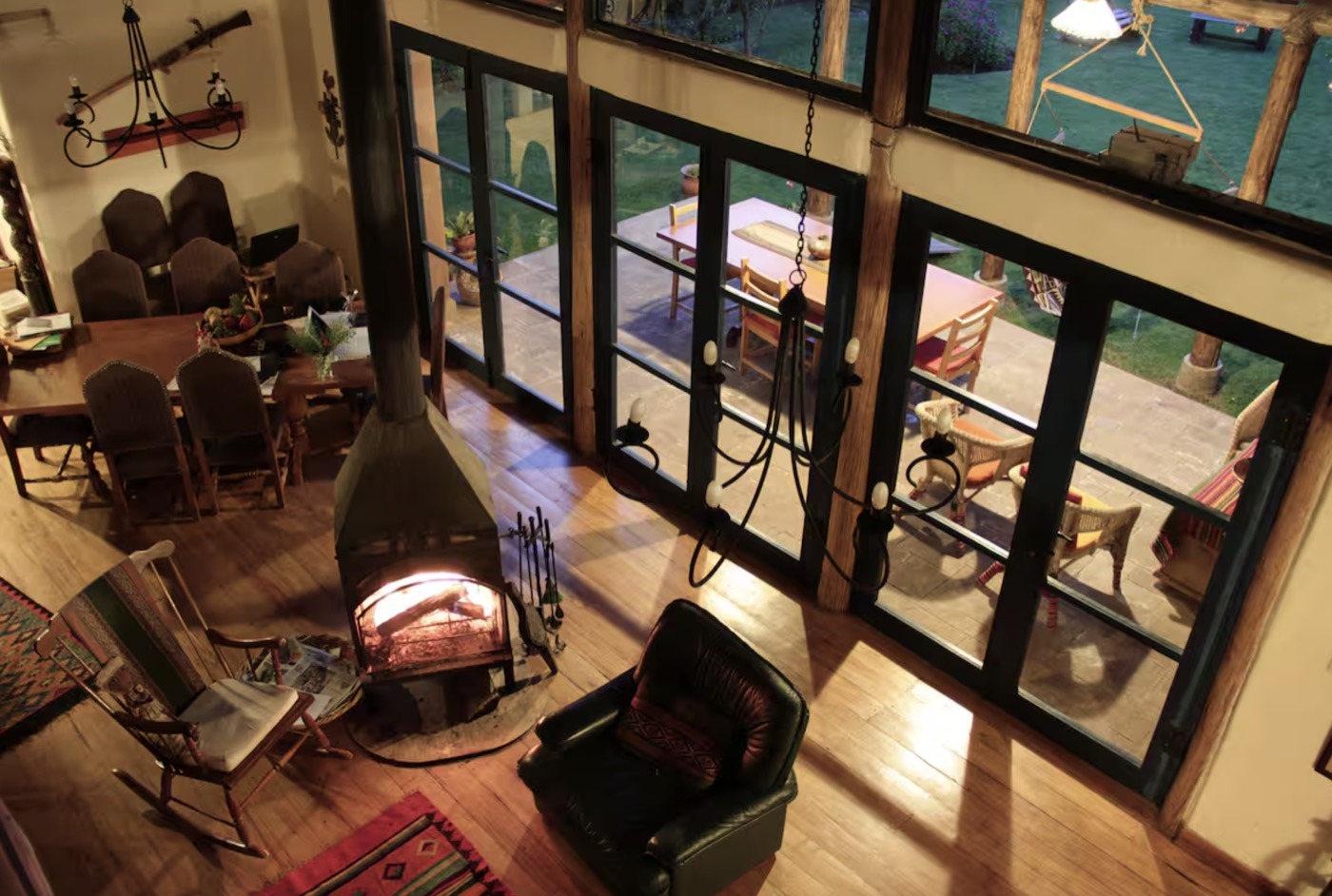 The lounge with a wood stove and tall windows