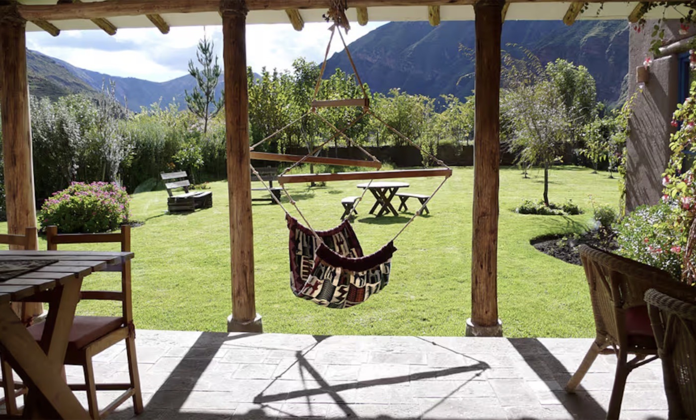 A hammock on the terrace looking over the lawn and the mountains